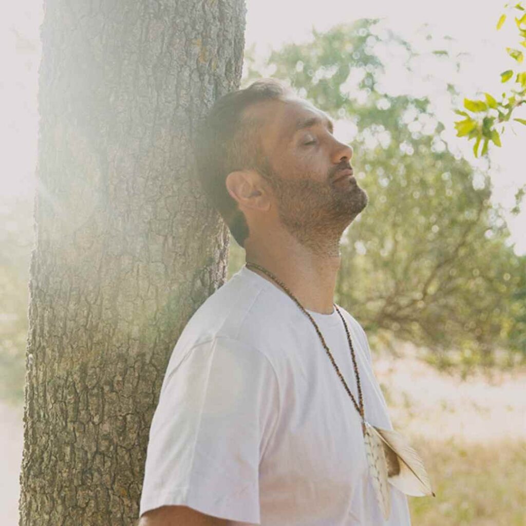 omprakash meditating with his back on a tree